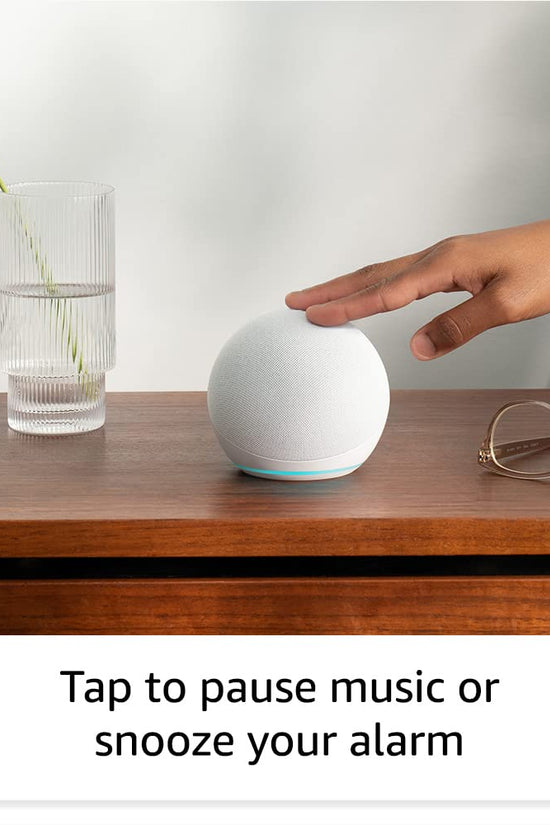 Alaxe Mini Bluetooth Speaker on wooden table with hand tapping to pause music next to a glass vase and eyeglasses