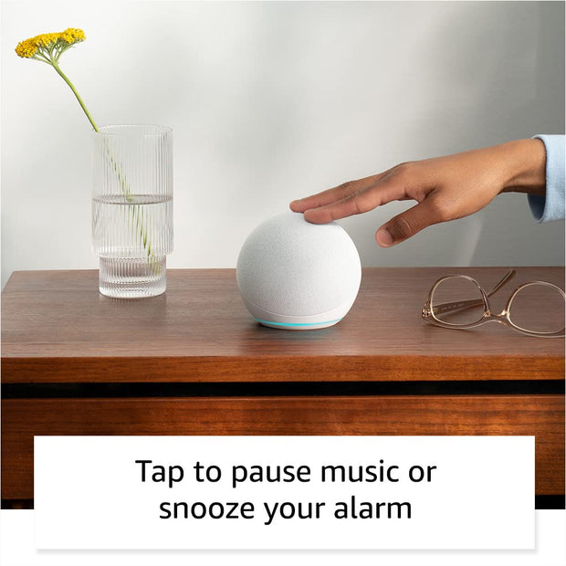 Alaxe Mini Bluetooth Speaker on wooden table with hand tapping to pause music next to a glass vase and eyeglasses