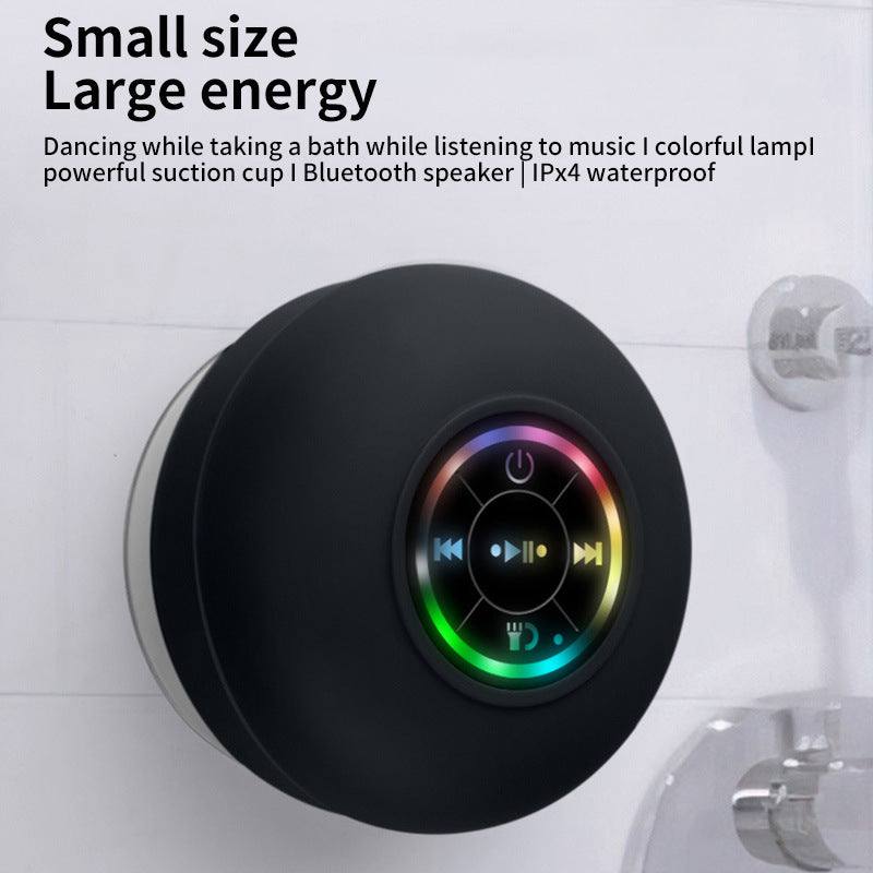 Compact waterproof Bluetooth shower speaker with suction cup and LED mood light attached to bathroom wall